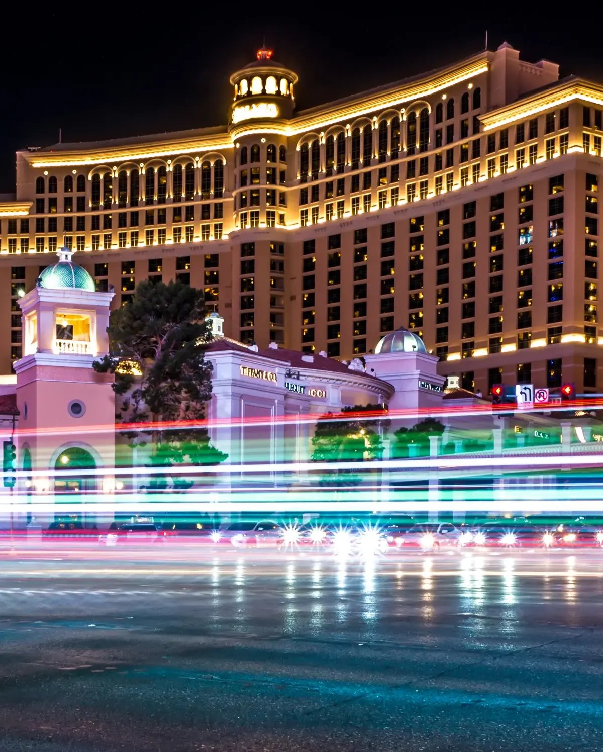 A Las Vegas casino hotel at night with long exposure streaks of light from moving traffic