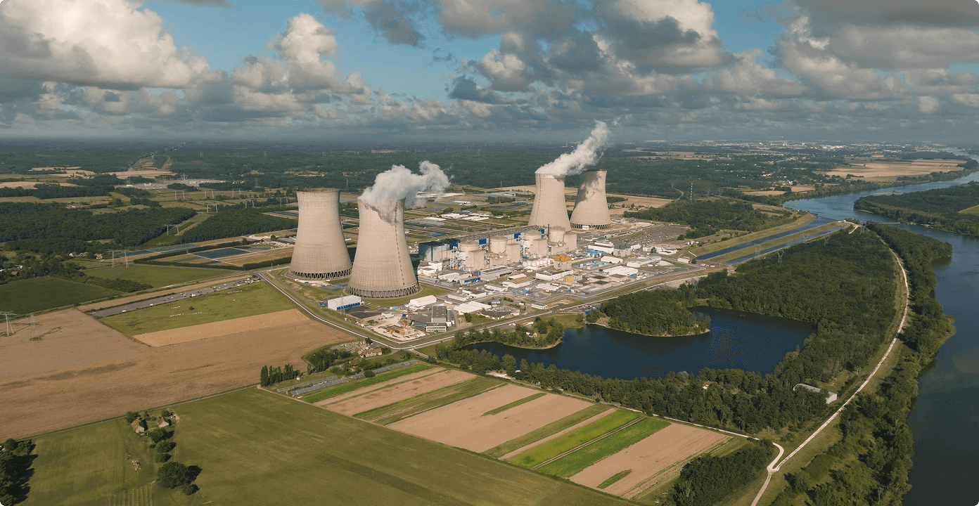 An aerial view of a nuclear power plant with four cooling towers, representing critical energy infrastructure